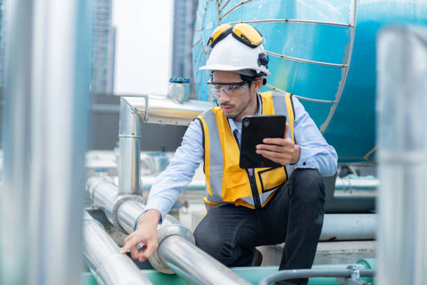 istock Engineer under checking the industry chilled water fan coil unit air conditioner is water cooling tower air chiller HVAC system of large industrial building to control air system 2158436677
