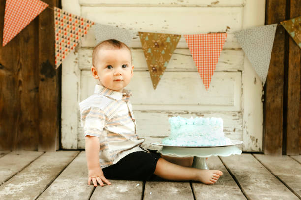 istock One Year Old Baby Boy With His Birthday Cake 2158436742