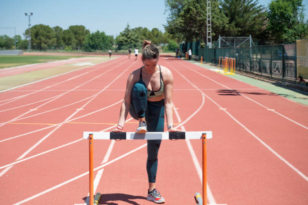 istock Female athlete training for hurdles on an outdoor track 2158437310