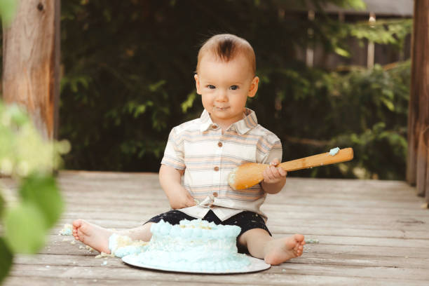istock One Year Old Baby Boy With His Birthday Cake 2158437947