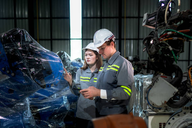 istock team engineers inspecting on machine with smart tablet. Worker works at heavy machine robot arm. The welding machine with a remote system in an industrial factory. Artificial intelligence concept. 2158438877