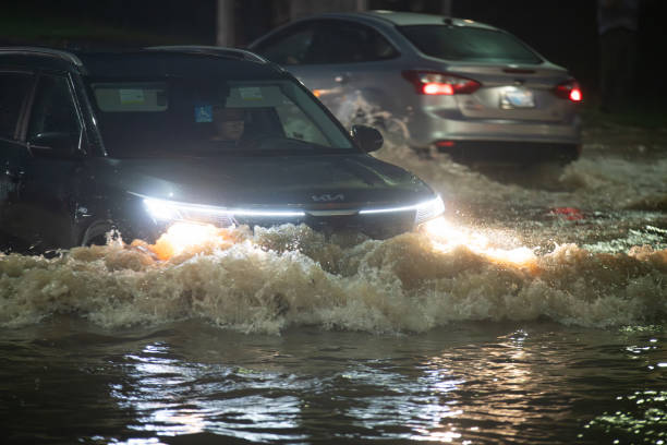 July 21, 2023 - Sackville, Nova Scotia - Drivers make their way through deep flood water after record setting rainfall caused the Little Sackville River to overflow well beyond its banks onto Sackville Drive.