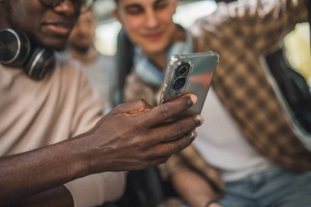 istock Two unrecognizable friends are looking at a mobile phone screen during a bus trip 2158440880