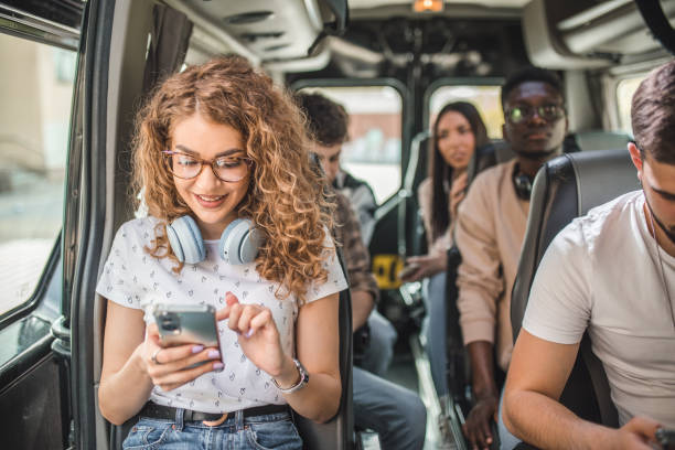 istock Young people use their mobile phones while traveling by minibus 2158441093