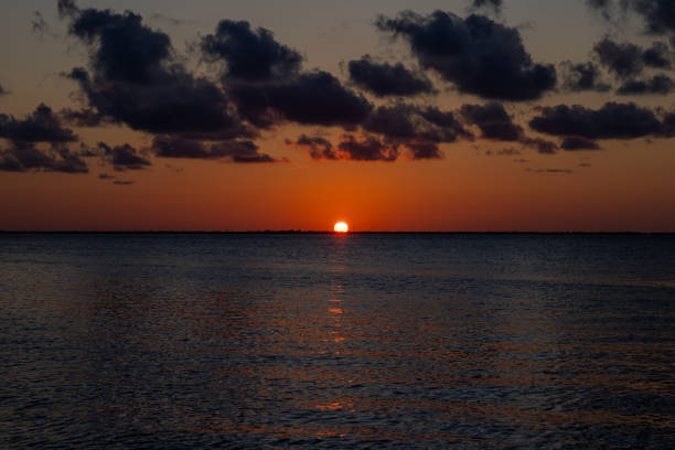 A stunning sunset over the ocean, with vibrant colors and dramatic clouds creating a serene and tranquil scene.