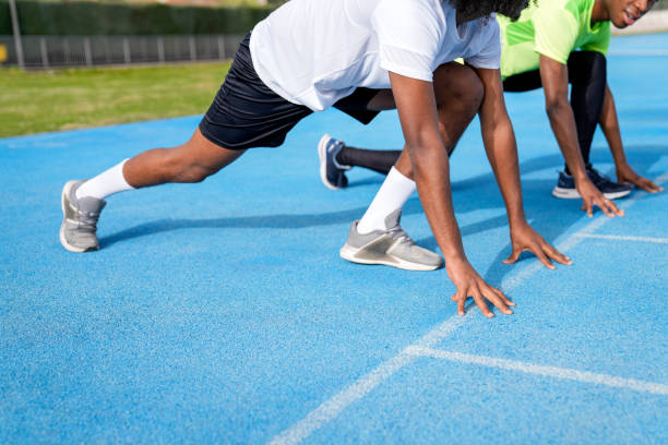 istock Three african men are lined up on a track, preparing to run 2158442765