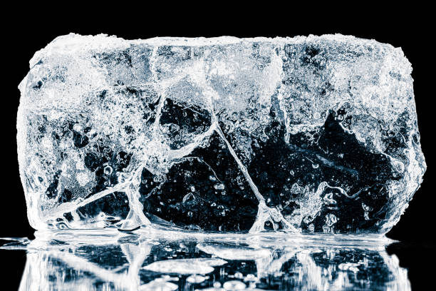 istock Crystal clear textured natural ice block with cracks on a black background. 2158444806