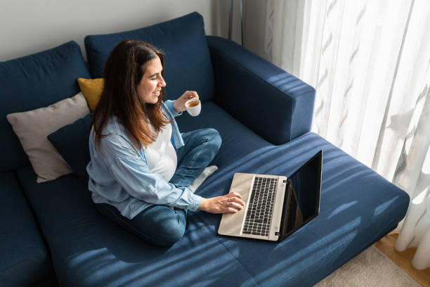 istock Cheerful pregnant woman drinking beverage on sofa at home 2158446007