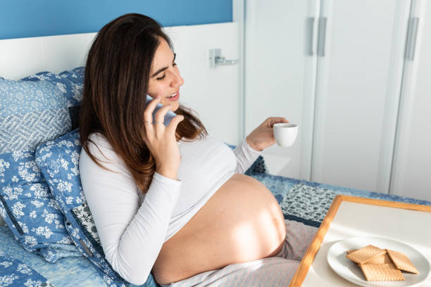 istock Pregnant woman having breakfast and talking on smartphone 2158446072