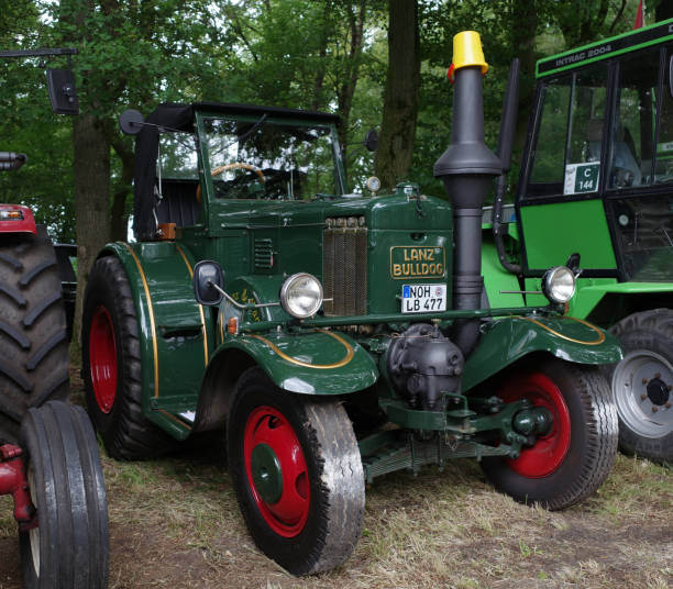 Front of an green antique tractor with a 16 kilometer sign