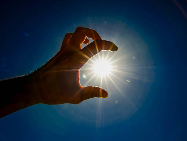 istock A hand is holding a sun in the sky 2158454038