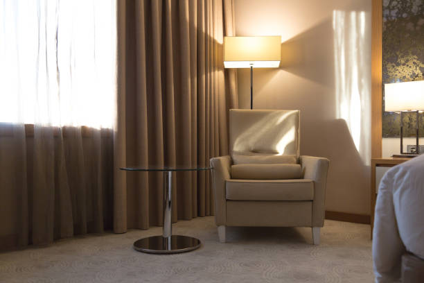 Simple-style living room featuring an armchair, grey sofa, coffee table, and living room cabinet, set against ceramic-tiled flooring and a white wall background.