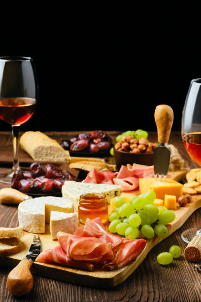 istock Plate with prosciutto, grapes, honey, dates, crackers, nuts and wine 2158456259