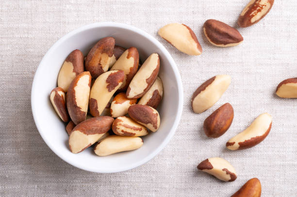 istock Brazil nuts, dried seeds in a white bowl on linen fabric 2158456592