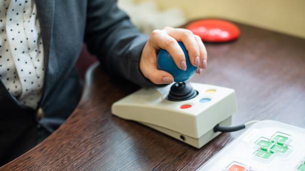 Woman with cerebral palsy works on a specialized computer mouse. Woman with cerebral palsy works on a specialized computer mouse assistive technology stock pictures, royalty-free photos & images