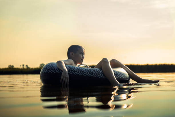 istock Boy enjoys a summer day at the lake with a rubber ring. 2158458141
