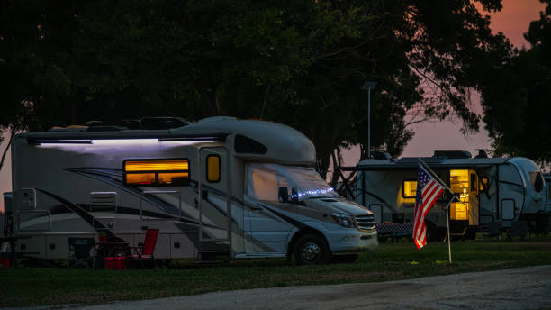 Rv motorhome and travel trailer parked at campsite at dusk with America Flag for holiday