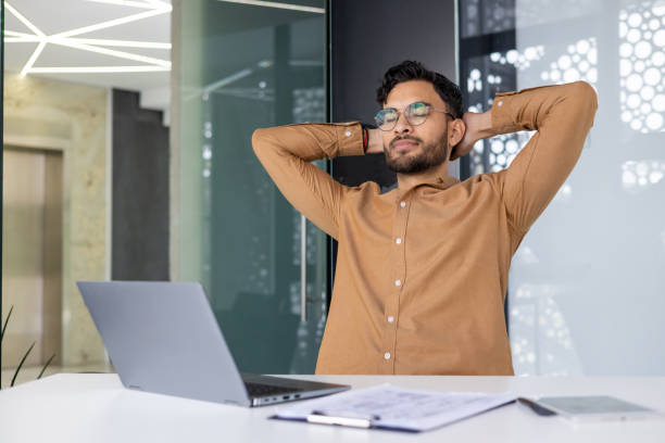 istock Confident businessman taking a break in modern office, feeling relaxed and accomplished 2158463557