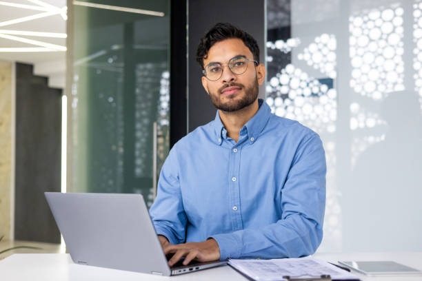 istock Confident businessman working on laptop in modern office space 2158464724
