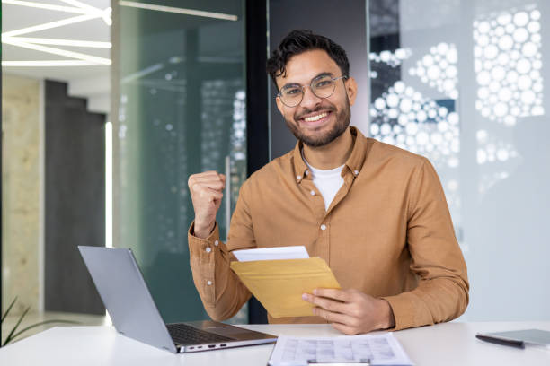 istock Happy businessman celebrating success while reading letter in office 2158465299