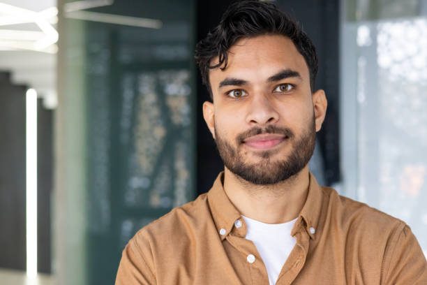 istock Confident young man with beard smiling in a modern office environment 2158470093