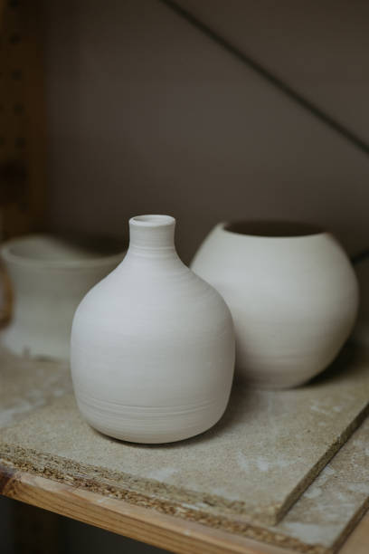 istock Unfinished White Ceramic Vases on a Shelf Reflecting the Process of Pottery Making 2158473354