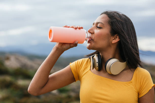 istock Ethnic woman drinking water from reusable bottle 2158477026