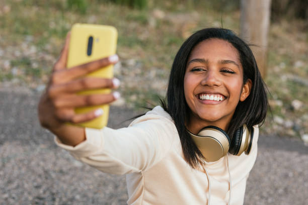 istock Ethnic woman on longboard taking selfie on smartphone 2158477185