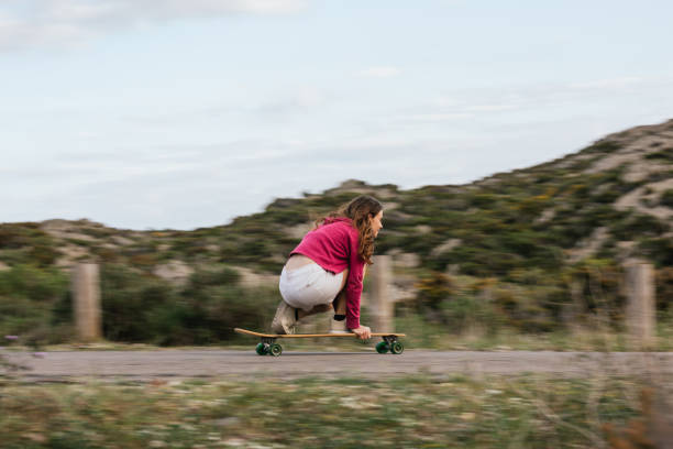istock Smiling woman riding longboard on asphalt road 2158477278