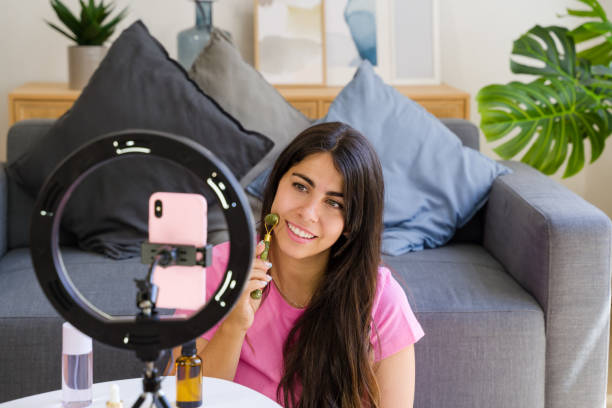 istock influencer using jade roller and filming skincare routine with phone 2158482049
