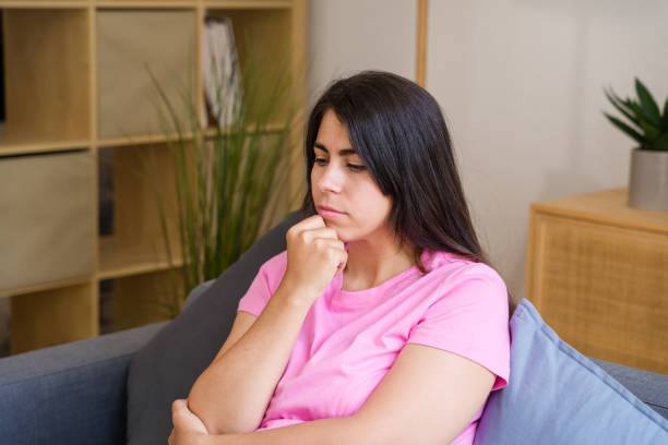istock woman is sitting on sofa and feeling sad at home 2158482212