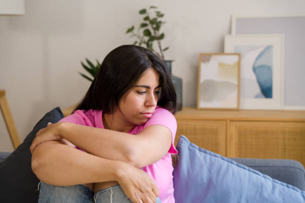 istock woman feeling sad and lonely while sitting on a sofa 2158482336