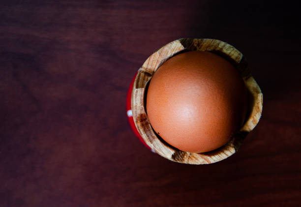 Brown eggs arranged around an open carton on a white background, showcasing natural farm-fresh produce in a clean, minimal studio setting.