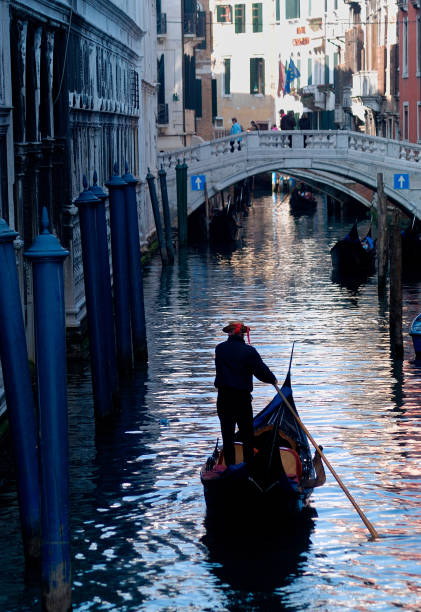 gondolier and gondola on a canal in Venice, Italy