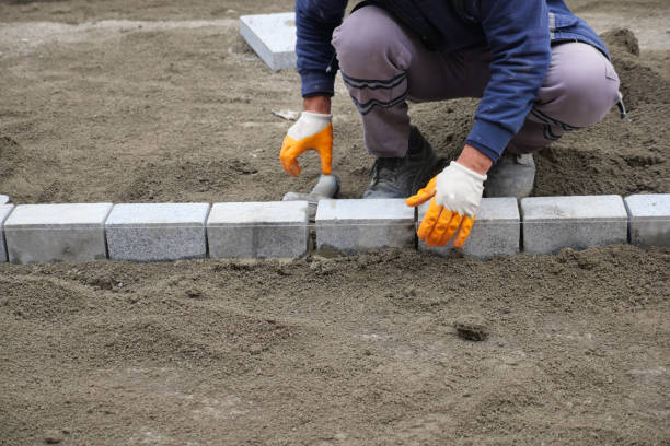 istock a worker laying concrete bricks on each other for building a new sidewalk 2158486907