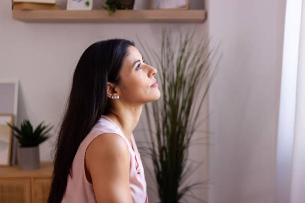 istock Young woman looking up and thinking at home 2158489242
