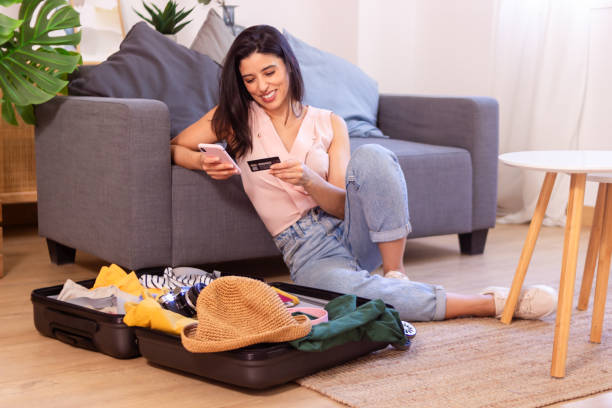 istock Woman paying online with credit card while packing for travel 2158489367