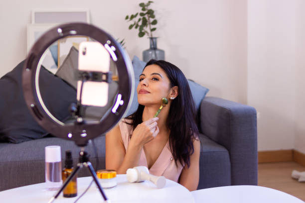 istock Influencer applying gua sha stone during livestreaming session 2158489388