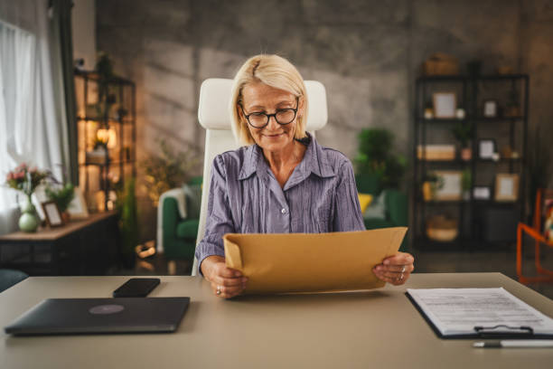 istock Mature woman work from home open with good news letter post envelope 2158490590
