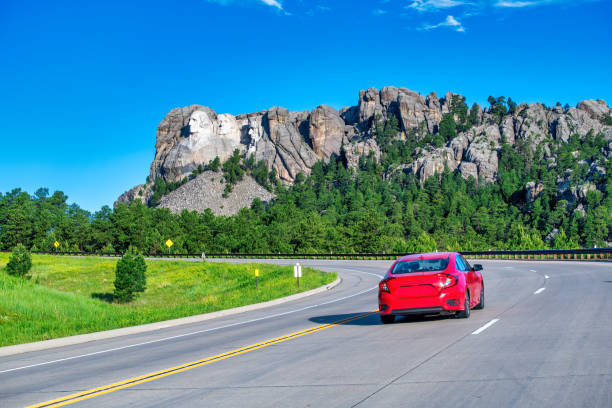 Red car entering Mt Rushmore National Monument.