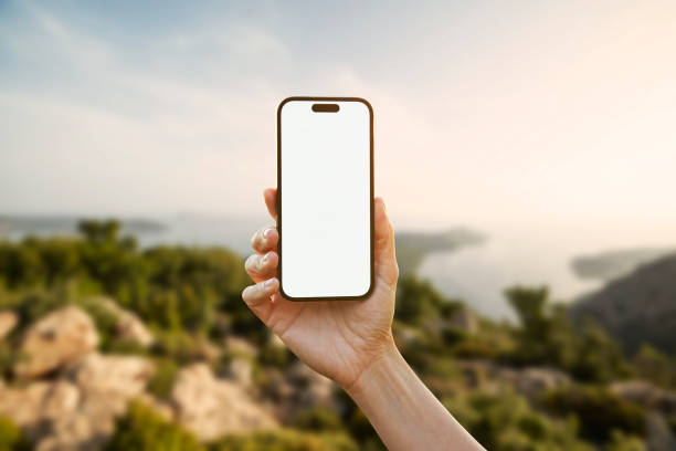 istock Young woman showing mobile phone blank white screen on Marina Background 2158492319