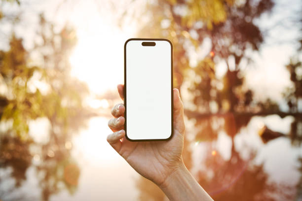 istock Young woman showing mobile phone blank white screen on Marina Background 2158492334
