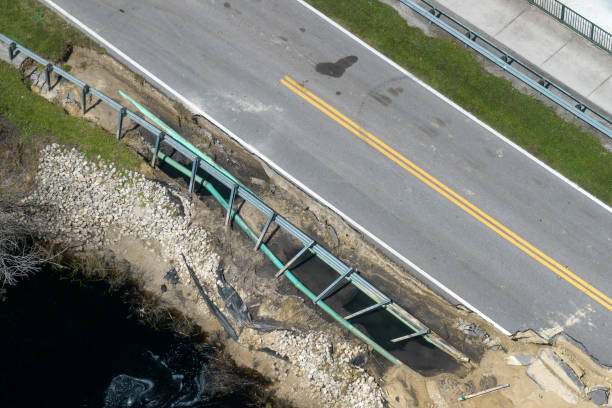 istock Destroyed bridge after hurricane flooding in Florida. Construction roadwork site. Reconstruction of damaged road after flood water washed away asphalt 2158494100