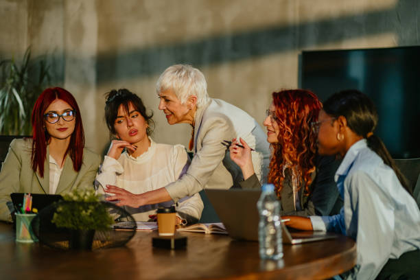 istock Interracial team listening their senior female tutor explaining at office 2158502408