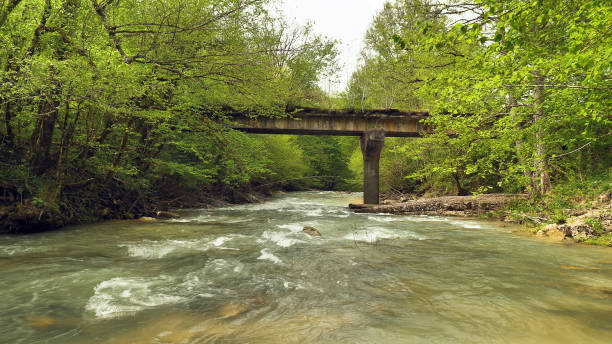 istock A serene view of a turbulent mountain river flowing under a concrete bridge 2158502905