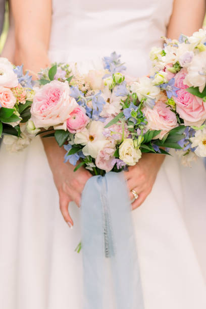 istock Bride is standing and holding a bouquet with a light blue ribbon. 2158503248