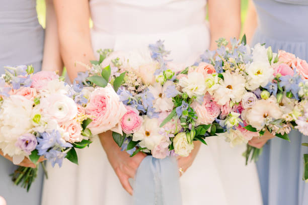 istock Bride and bridesmaids standing together holding pretty springtime bridal bouquets. 2158503252