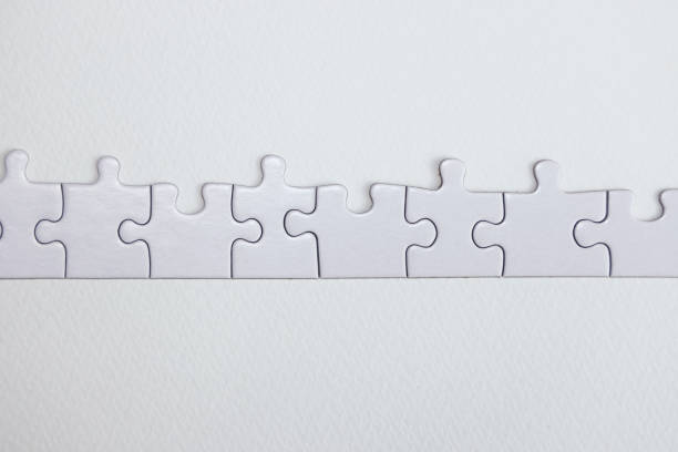 istock White jigsaw puzzle pieces on a white background. 2158506250