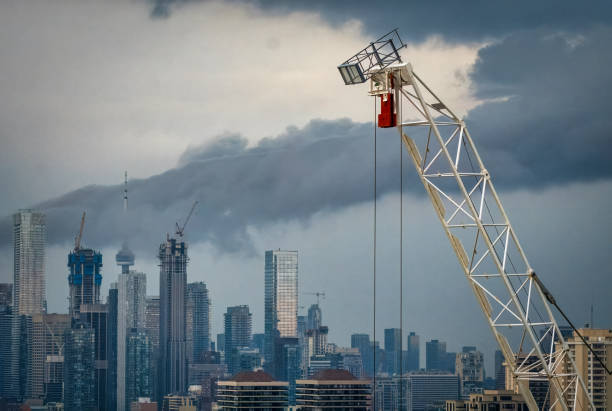 Multiple high-rise building construction sites with cranes from midtown to downtown Toronto under stormy sky