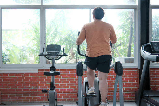 istock Overweight man exercising on an elliptical machine in the gym 2158509554